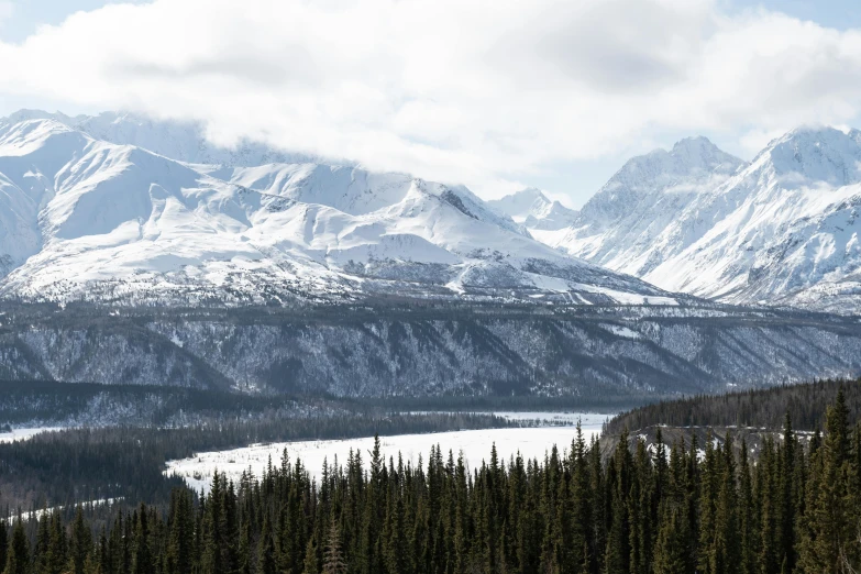 snow capped mountains rise in the distance above a mountain range