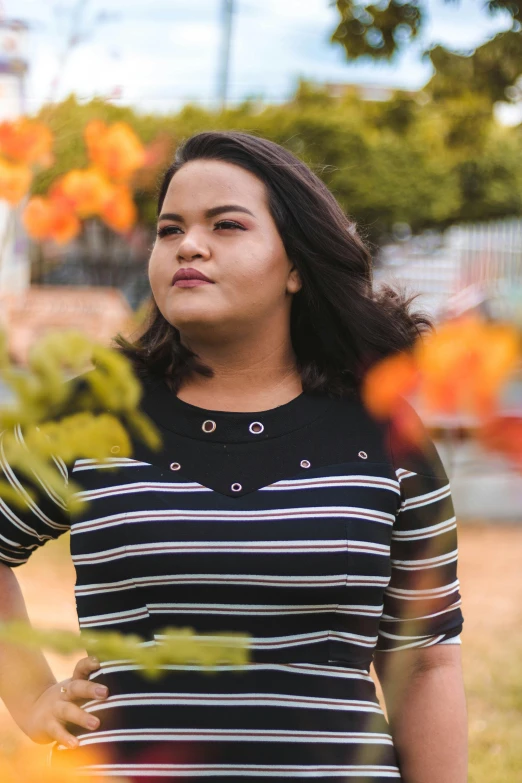 a women who is standing near orange flowers