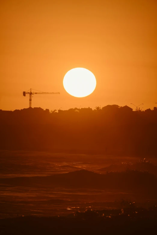 the sun is setting over the city and beach