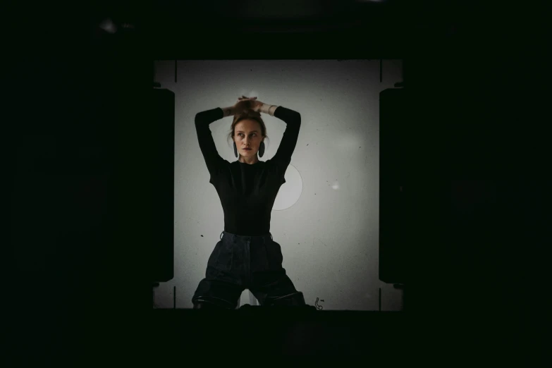 a woman in black stands behind a projection screen