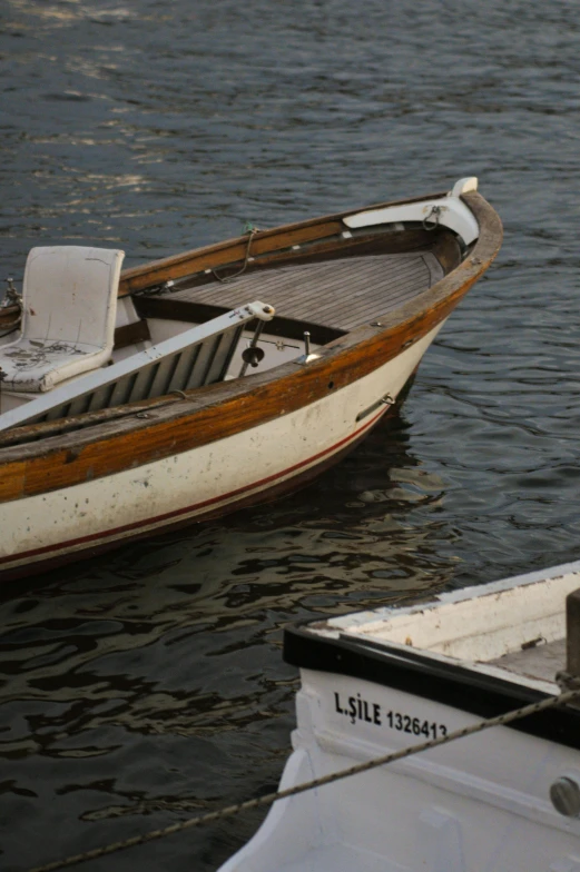 a small boat is docked next to another larger one