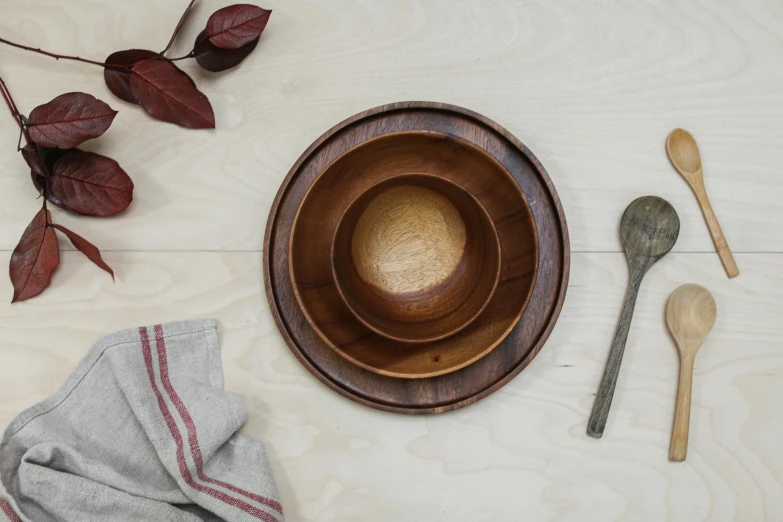 two wooden spoons and two bowls on a white counter