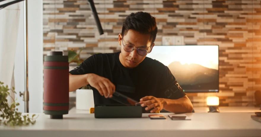 a man in glasses is using a keyboard and mouse