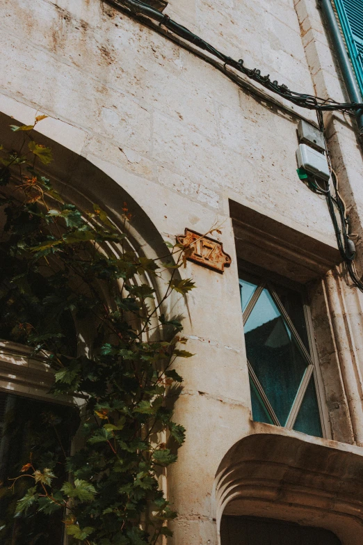 a rusted, peeling sign sits on the side of a brick building