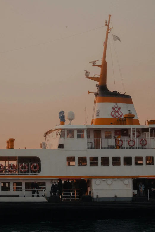 a ferry boat with passengers on deck is moving down the water