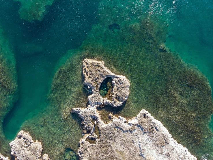 the ocean water has a rock formation in it