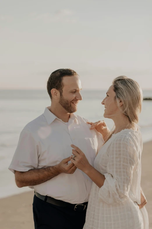 a man holding onto his wife on the beach