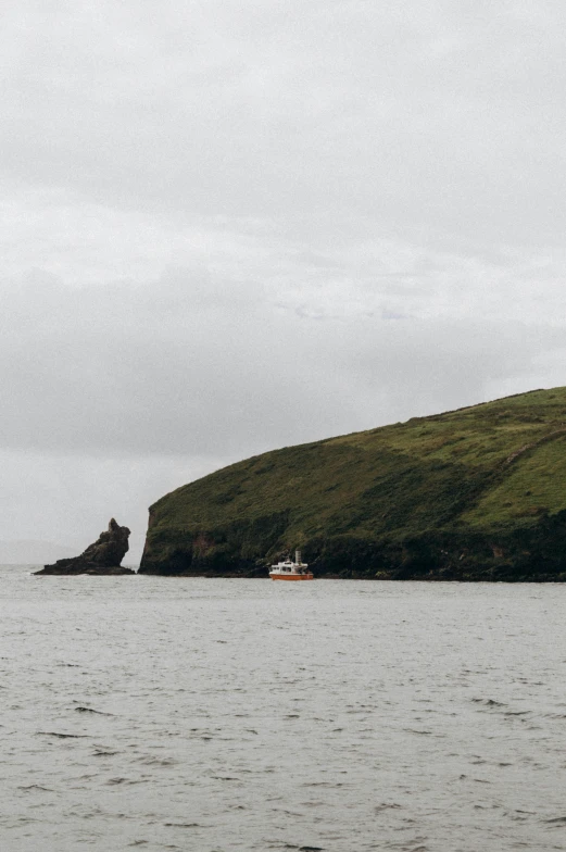 small boat in large body of water with island in background