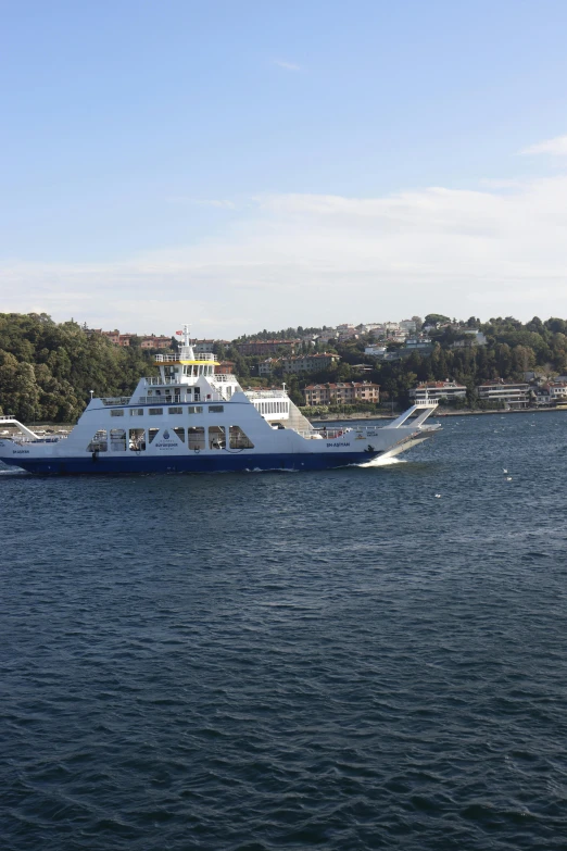 a large boat traveling across the water next to shore