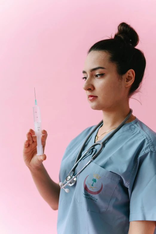 an asian doctor showing a syquet in her hand