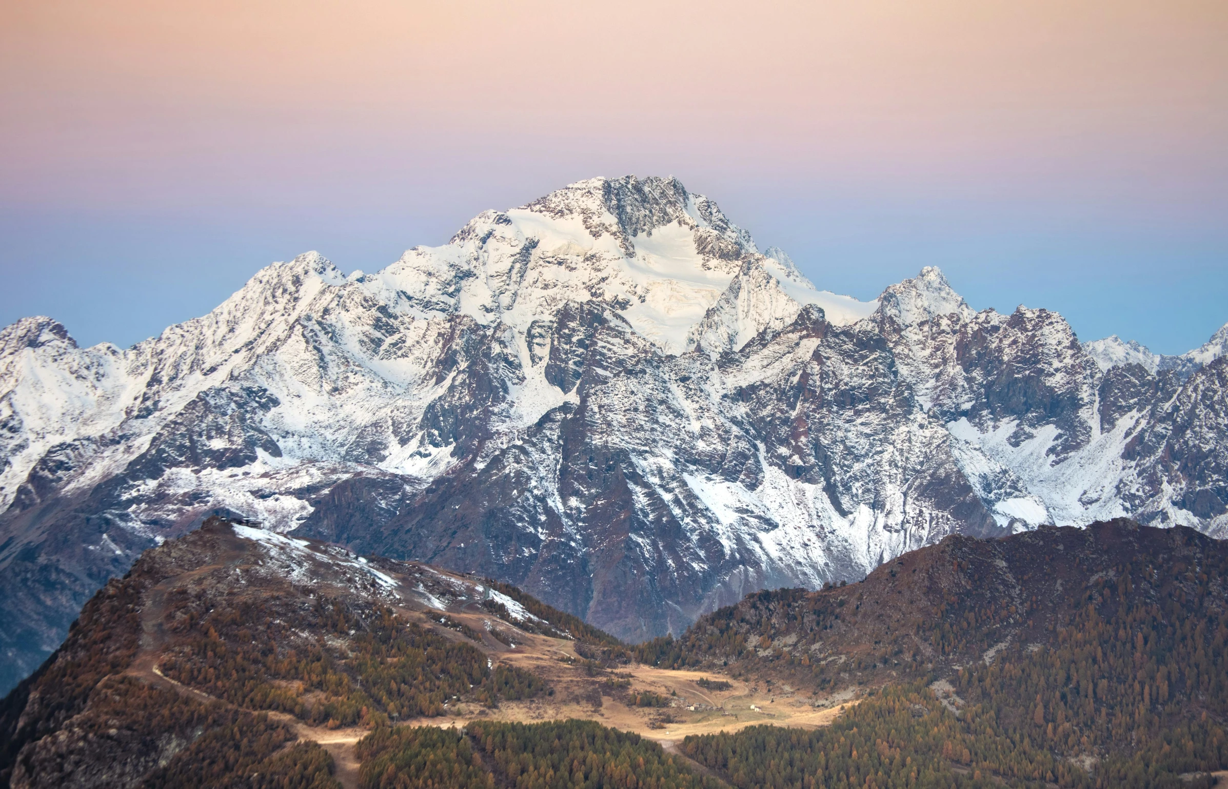 the white snow covered mountain peaks with green firs