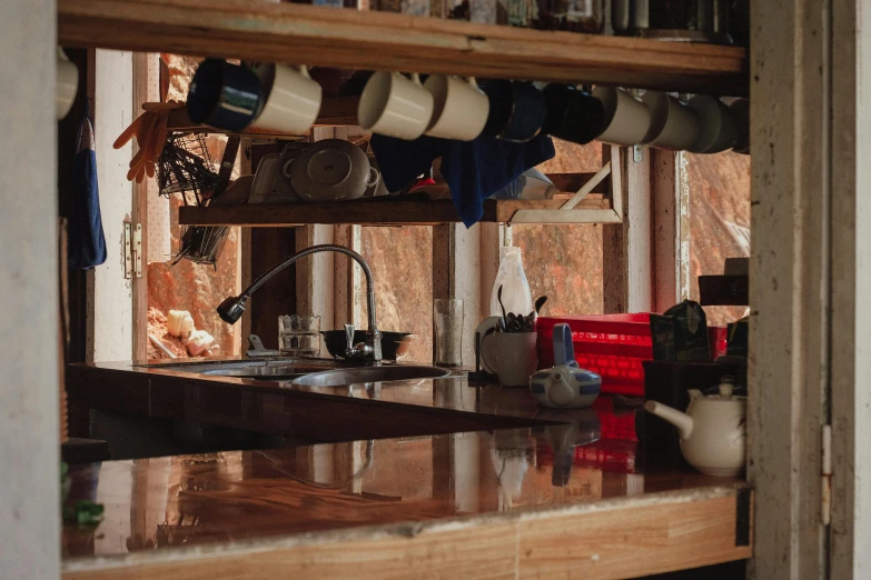 an unfinished kitchen with cups and pitchers hanging on the wall