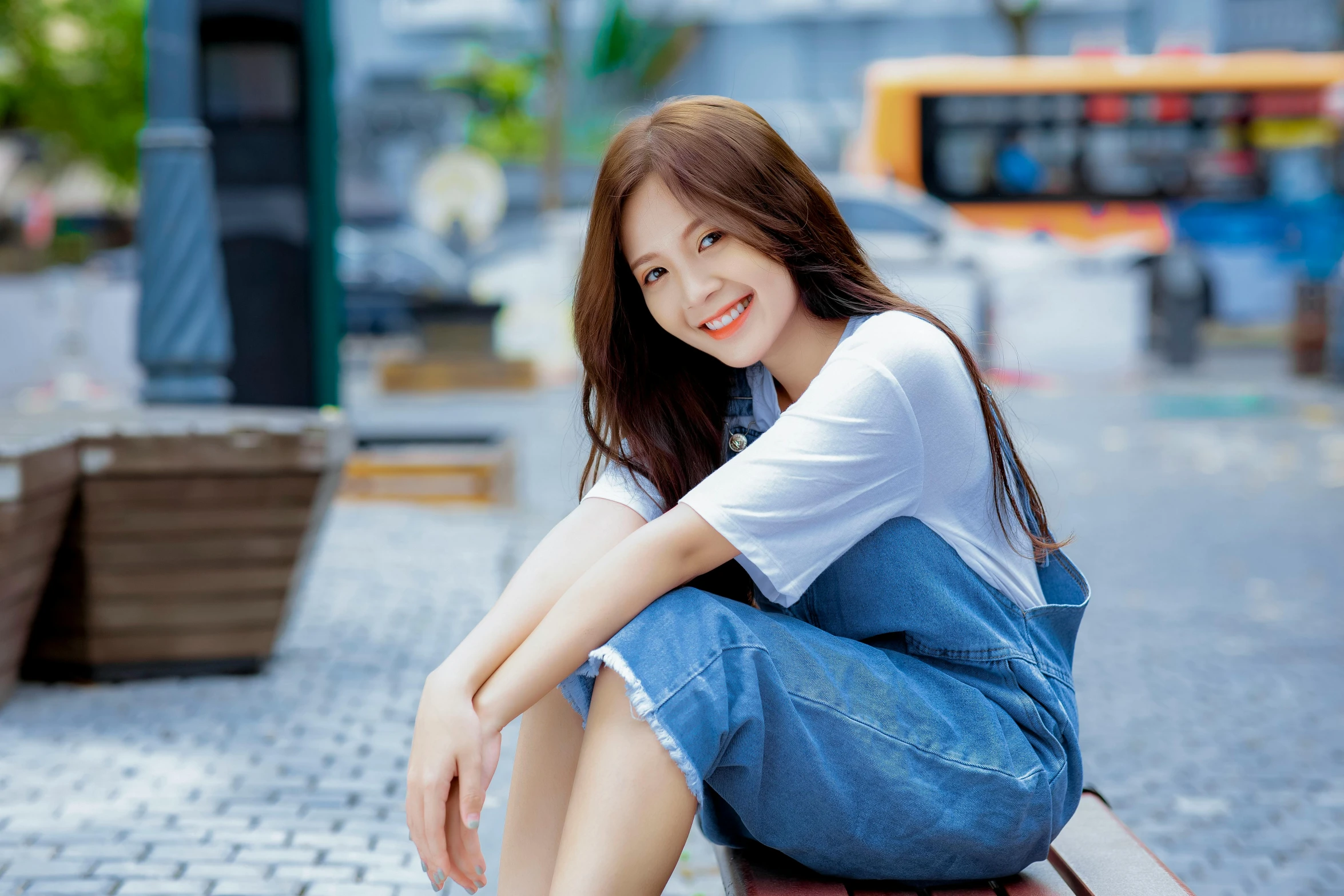 an asian woman sitting on a park bench in the city