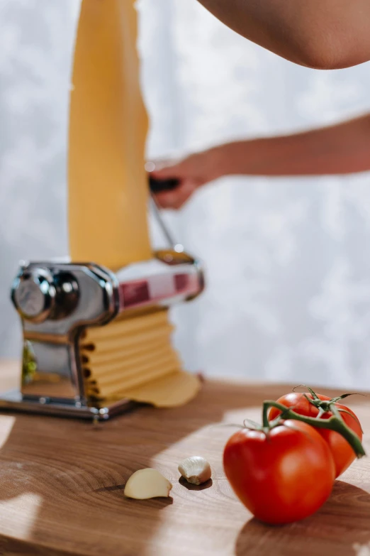 tomatoes and parmesan cheese being cut on a wooden  board