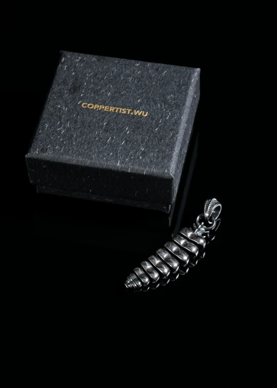 a black box with the word univerlrance written on it next to a silver metal key chain