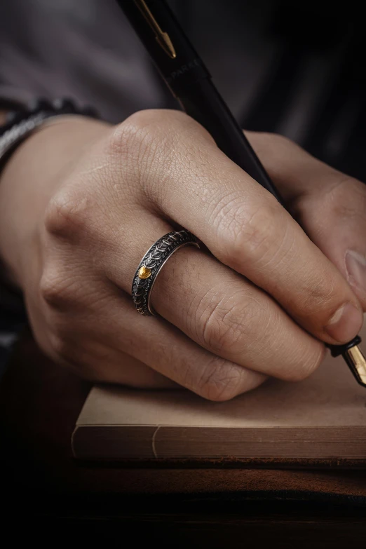 person holding a pen and writing on a notebook