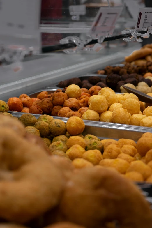 different types of food in metal pans on a store shelf