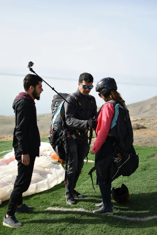 people on the ground standing with parachutes