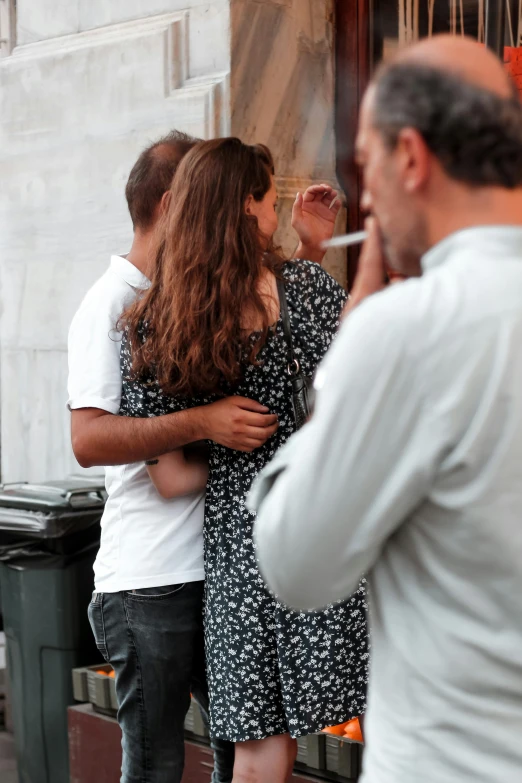 a group of young people standing around each other and smoking