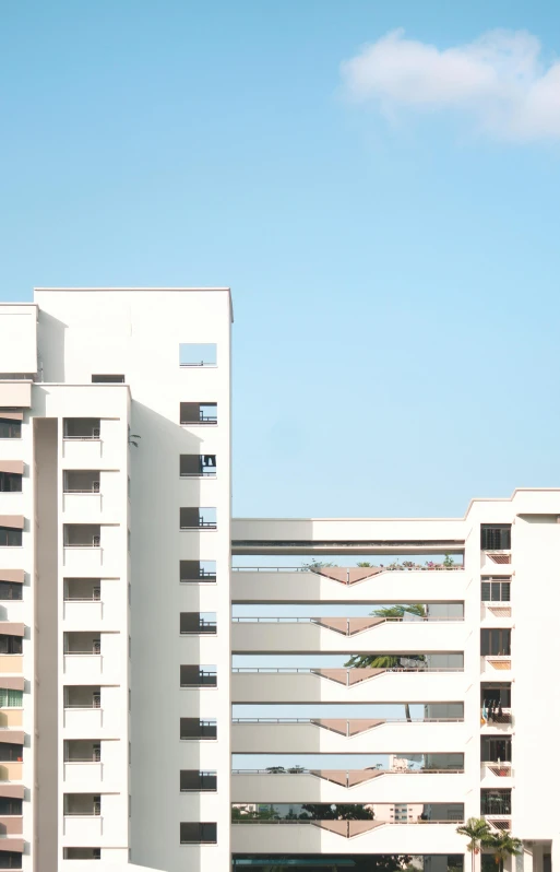 a white building in front of another building on a clear day