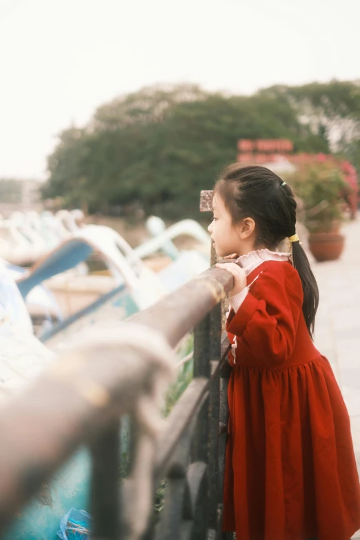 a  is standing behind the railing looking at boats