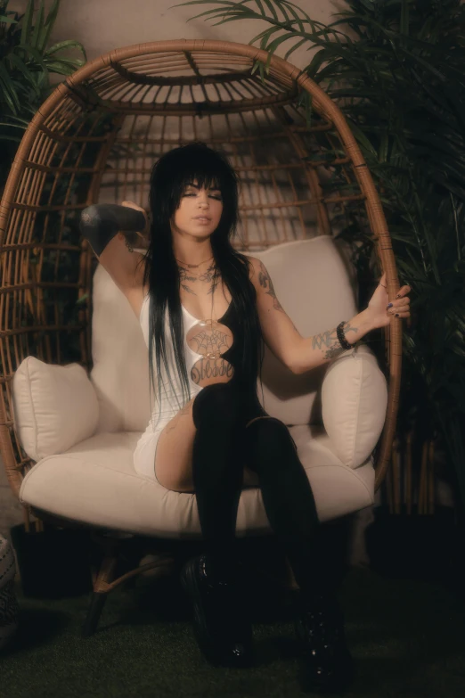 a woman with long black hair sitting on a white chair