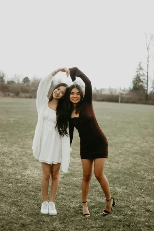 two women standing on their hands with one holding the other