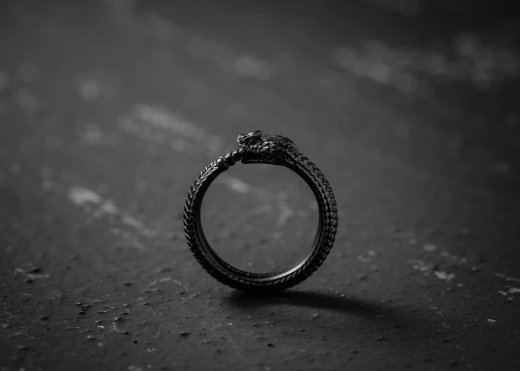 a dark colored ring made of black wire with a white diamond on top