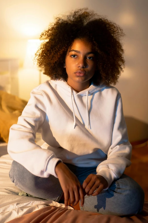 a young woman sitting on top of a bed