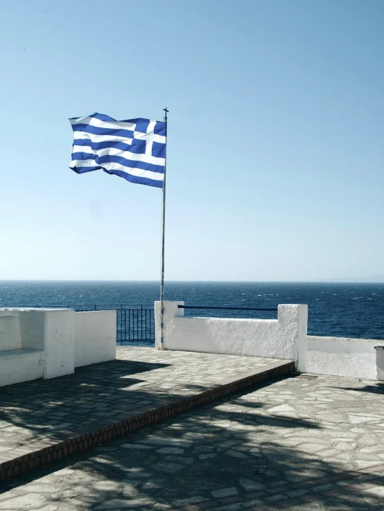 an greece flag at the edge of a beach