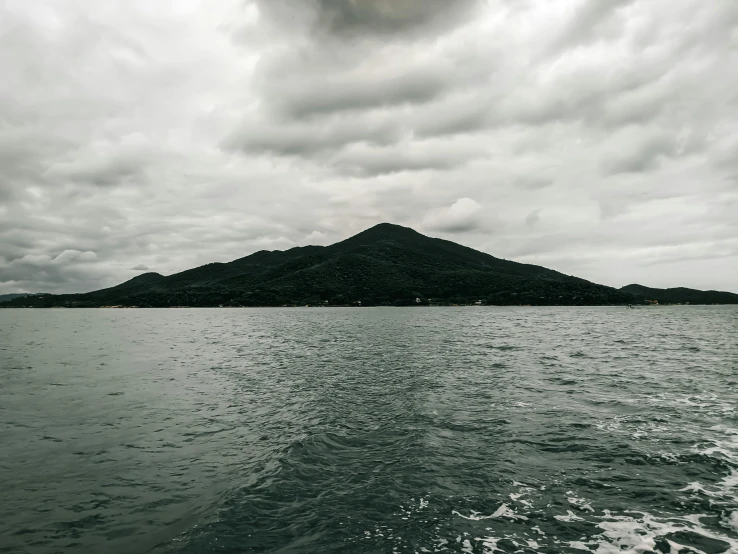 a mountain rises up on a small island on the water