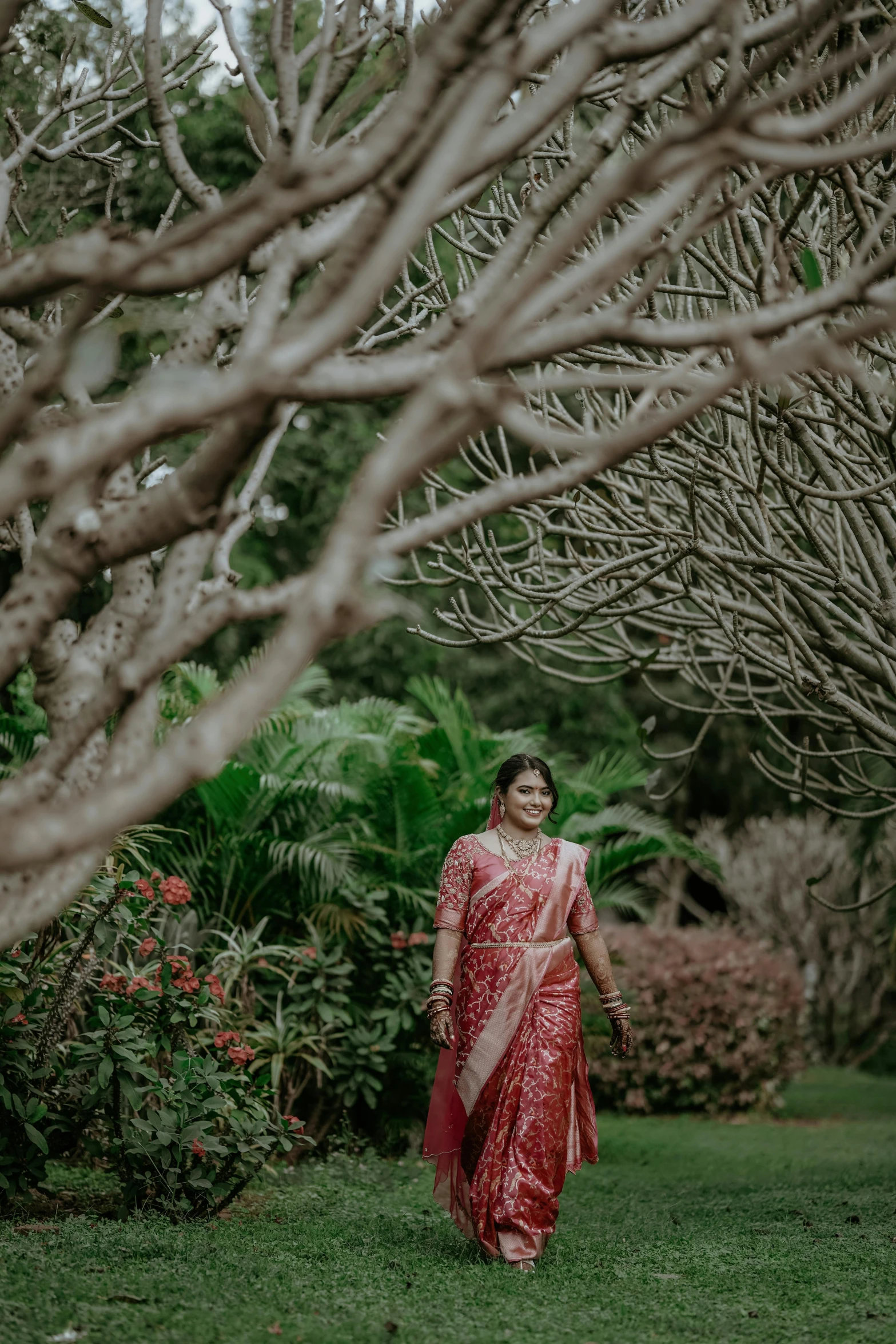 a woman walks through the woods in a red and white dress