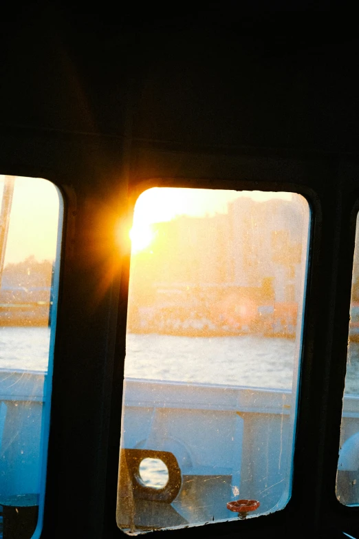 the sun sets behind the window of a ferry
