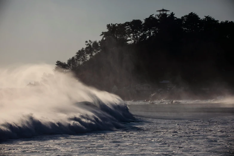 a large wave is crashing over a beach