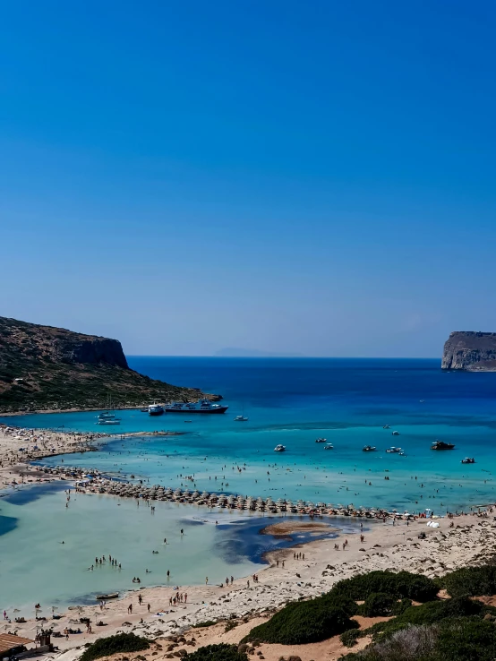 many people enjoying the clear blue water near the beach