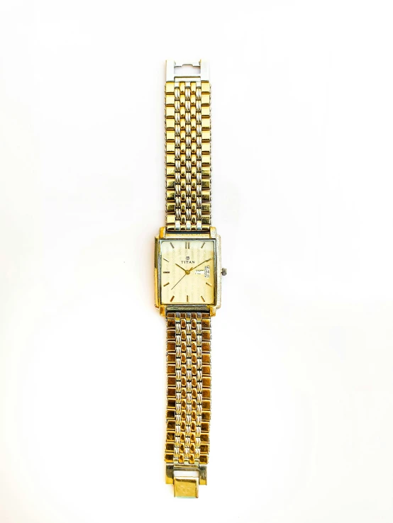 a gold watch on a white surface is shown