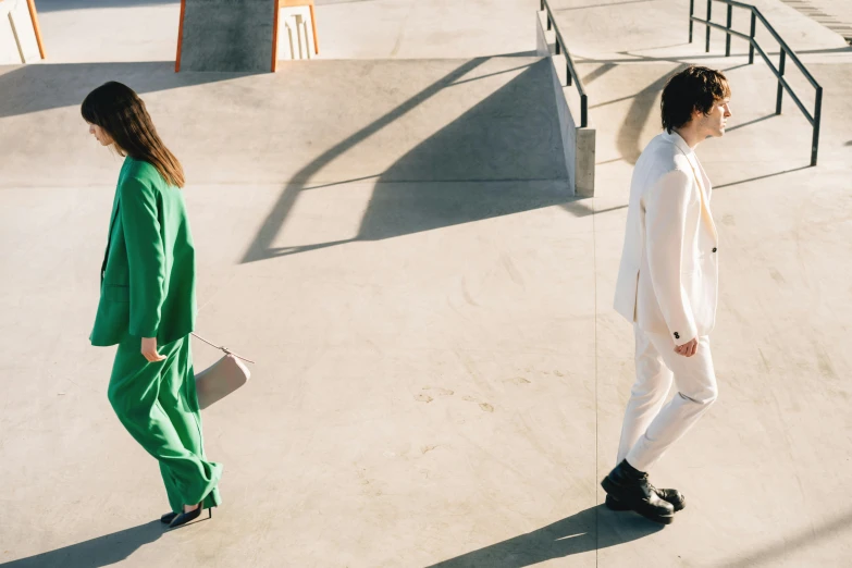 two young men in white suits stand on cement