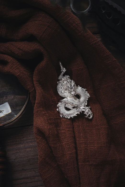 a small dragon brooch that is sitting on top of a shirt