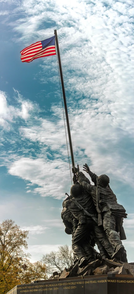 a memorial with a flag that has two soldiers holding a banner