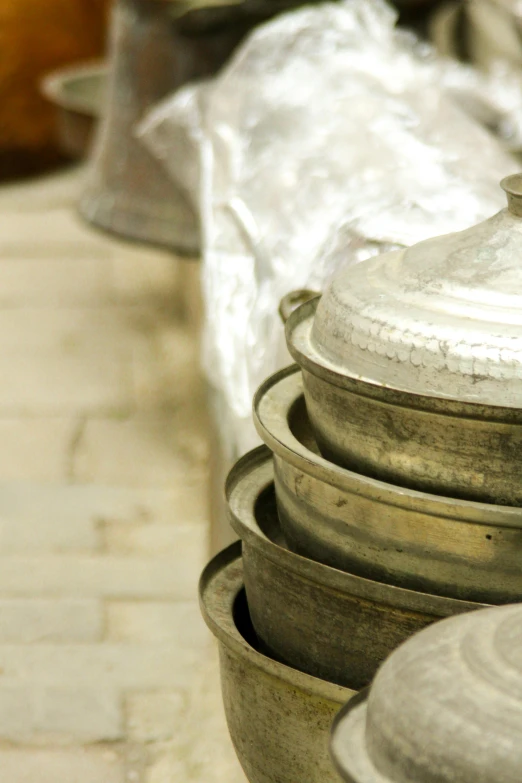 a set of large pots sit on the pavement