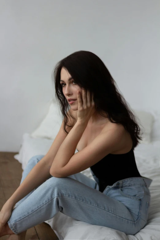 woman in black shirt sitting on floor talking on cellphone