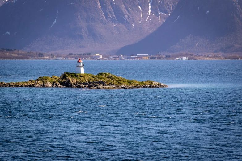 the boat is out in the blue water near a small lighthouse