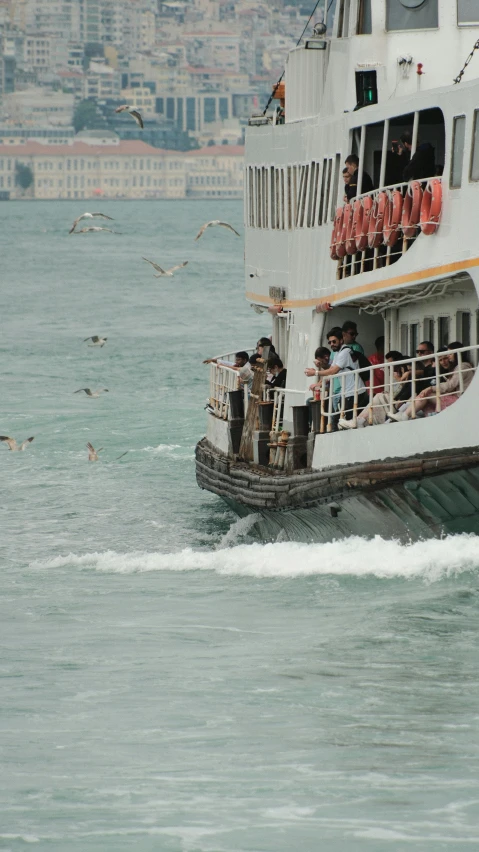 several people are on the balcony of a large boat