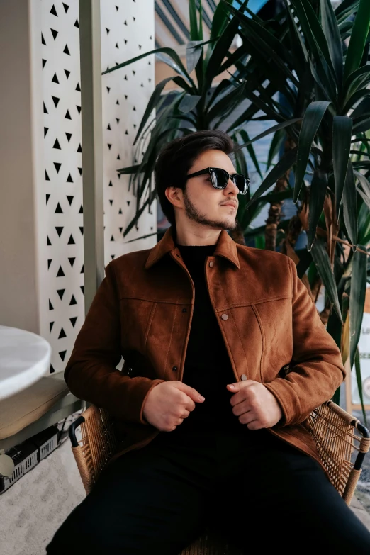 a man wearing sunglasses sits in a chair