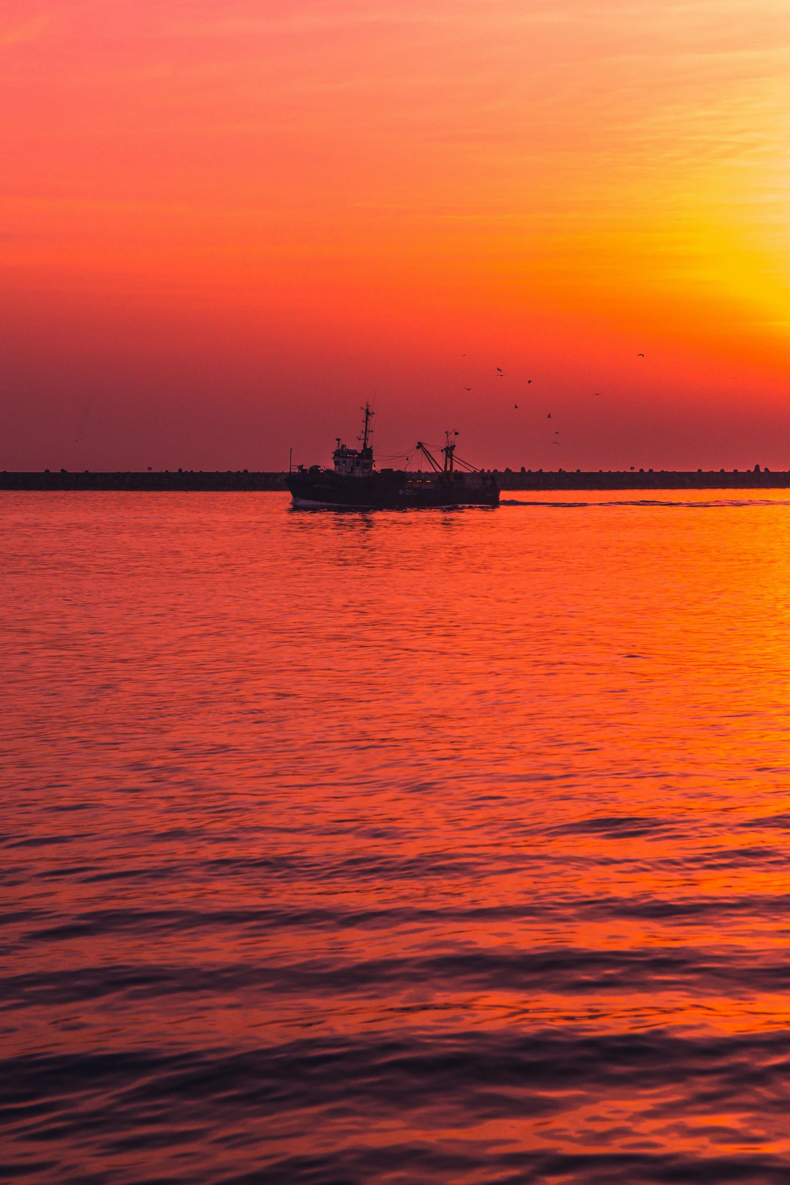 a large boat on top of the ocean at sunset