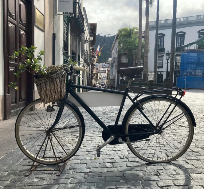 a bicycle sits parked on the side of a brick road