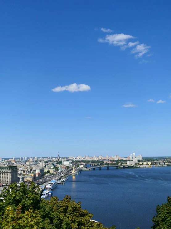 a river and city in the distance, with an airplane flying in the sky