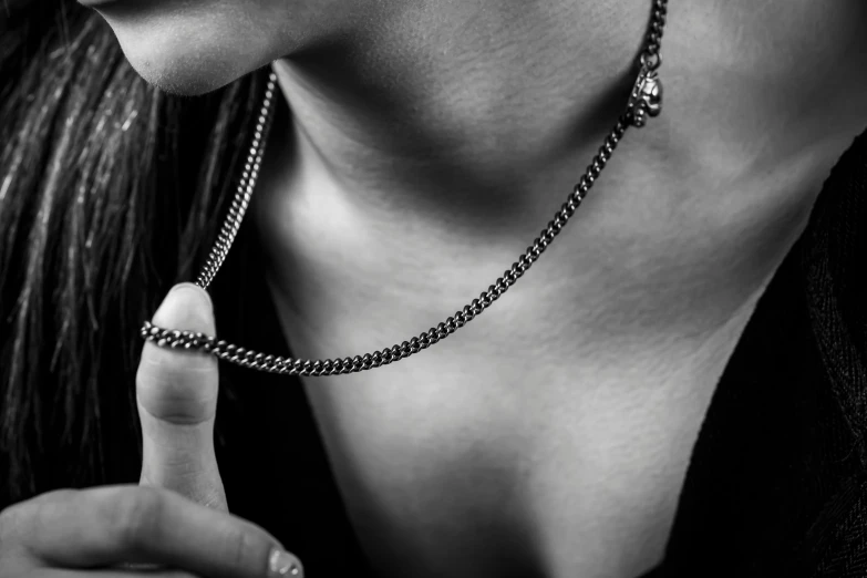 woman wearing a chain necklace making the finger sign