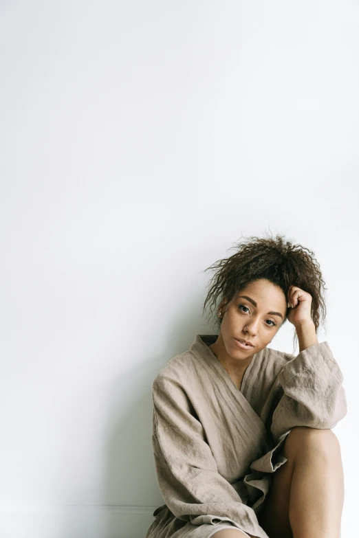 an african american woman sitting on the floor wearing sweats