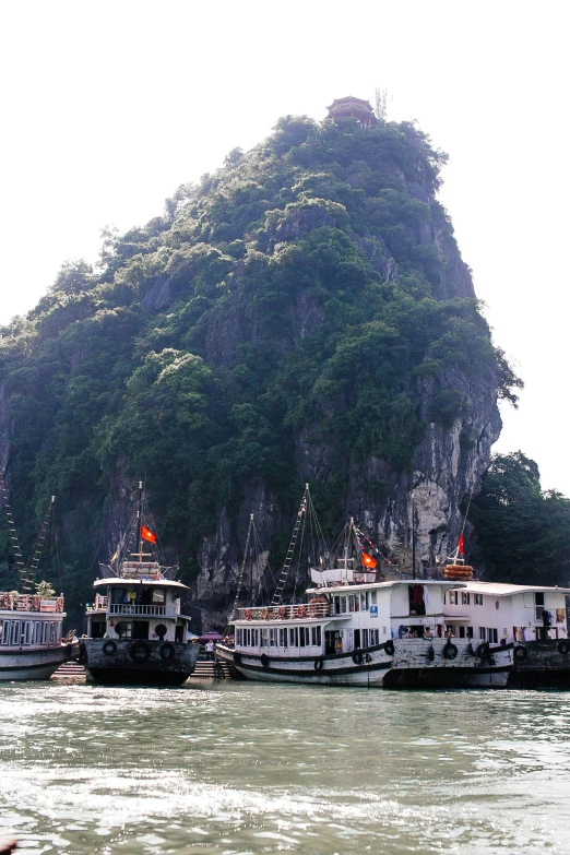 a couple of boats in front of a mountain